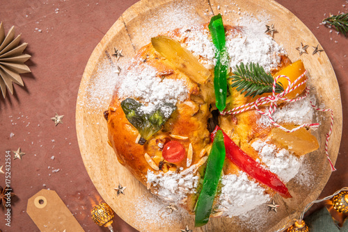 Wallpaper Mural Colorful candied fruits and powdered sugar on a traditional Bolo Rei or Kings Cake, set on a wooden board amidst warm holiday decorations and lights. Is tradicional for Christmas in Portugal. Top view Torontodigital.ca