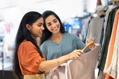 Fotografie Positive young fashion store associate woman giving help to customer