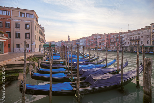 Gondolas lined up at sunset near canal in Venice, Italy showcasing iconic architecture