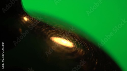 Abstract Swirls of Light and Texture on Dark Surface Against Green Background High Detail Macro Photography