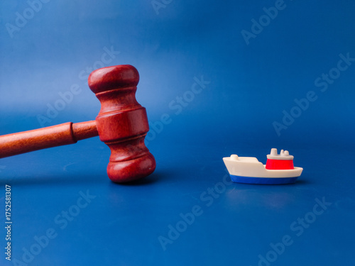 The image shows a gavel and a toy boat, which can be interpreted as a representation of maritime law or admiralty law