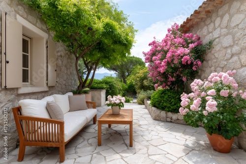Stone house patio featuring outdoor wooden furniture and pink flowers