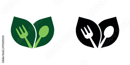 Silhouette of fork and spoon on two leaves. Healthy food concept logo vector illustration design. Green and black.