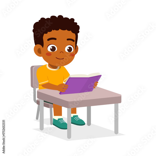 Cute African American Boy Reading a Book at His Desk with a Happy Expression