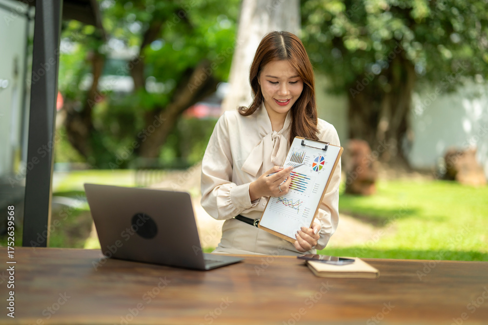 Obraz premium Asian businesswoman presenting business data during video call outdoors