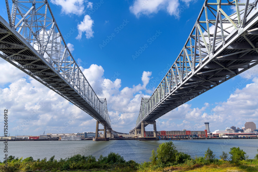 Naklejka premium Crescent City Connection Bridge - A low-angle and wide-angle view of the Crescent City Connection Bridge over the Mississippi River on a sunny Autumn morning. New Orleans, Louisiana, USA.