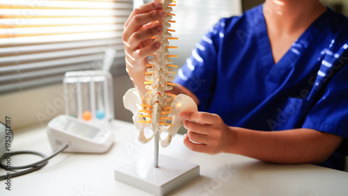 Foto An orthopedic surgeon holds a spinal model as he demonstrates treatment methods for human spinal injuries caused by back pain during a medical consultation