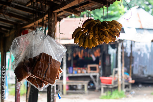 Vibrant bananas and local sweets hanging at the rustic roadside marketplace, offering a taste of authentic culture and simple pleasures in a bustling tropical destination