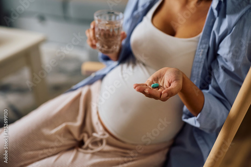 Obraz na plátně Close up of pregnant woman taking pills at home.