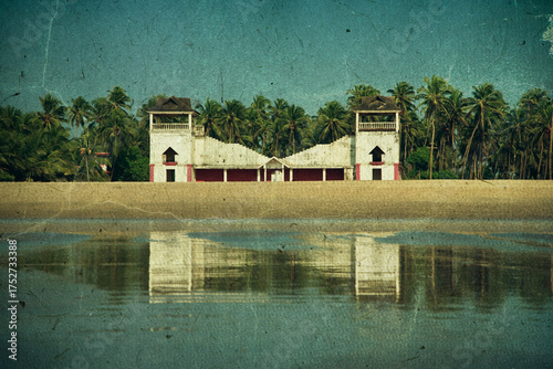 Canvas Print Goa, India - 2014: Ruined and abandoned villa standing on seashore against backg