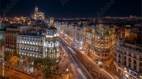 Illuminated gran vía street with blurring car light tails leading through the heart of madrid