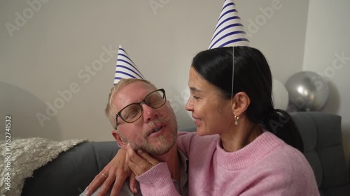 Couple Birthday Celebration Home Love - A couple wearing party hats smiles at each other while celebrating a birthday at home.