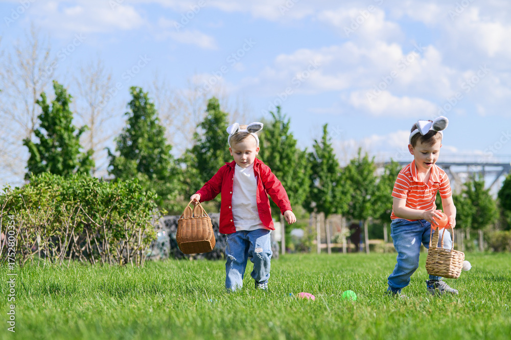 Obraz premium Kids Hunting Easter Eggs Outdoors on Sunny Spring Day