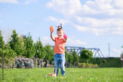 Smiling Boy Celebrating Easter Outdoors with Egg Hunt Basket