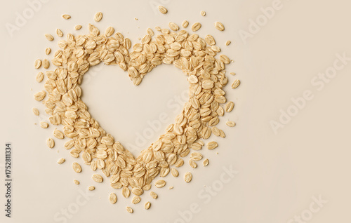 A heart-shaped frame crafted from rolled oats on a beige background for healthy living and breakfast themes