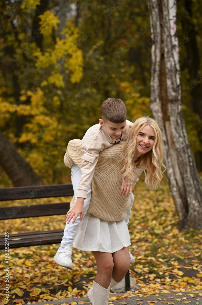 Fototapeta premium mother and son playing in the autumn park