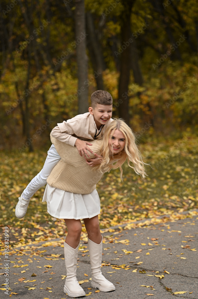 Fototapeta premium mother and son playing in the autumn park