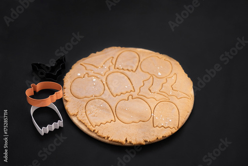 Halloween gingerbread cookies on a dark background. Homemade cookies for Halloween party - pumpkin, ghost, bat, mummy, skeleton. Halloween background with space for text. Top view. Mock up