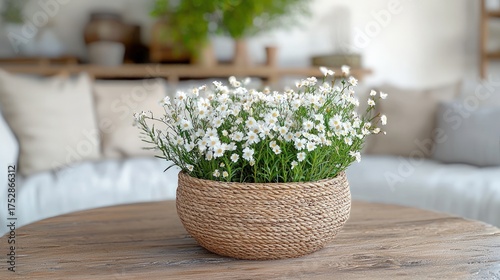 A beautiful potted plant with small white flowers sits on a wooden table.
