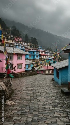 Colorful houses line a winding cobblestone path under a cloudy sky in a mountain village