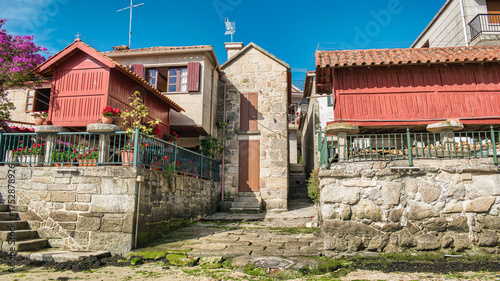 Cuadro en lienzo Casas de piedra y tradicionales hórreos gallegos pintados de rojo en la villa de