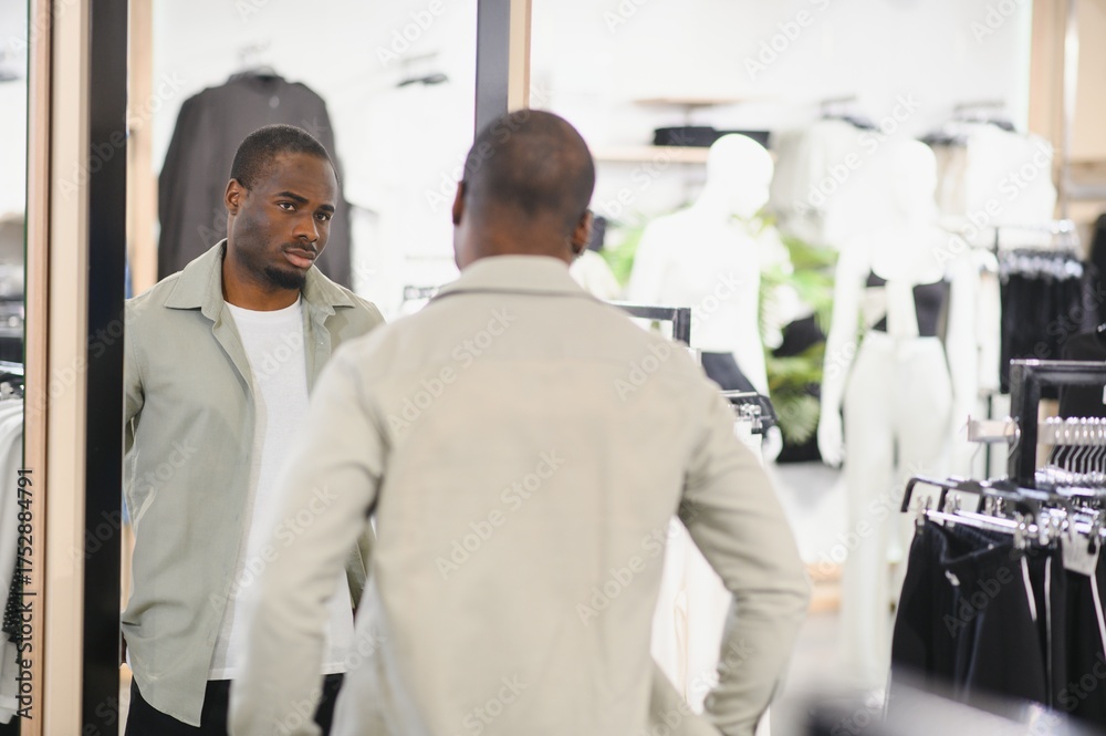 Obraz premium Stylish man choosing clothes in fashion store mirror