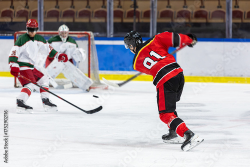 Ice hockey player shoots the puck against the opponents net