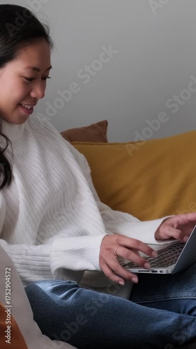Young asian woman typing on laptop computer