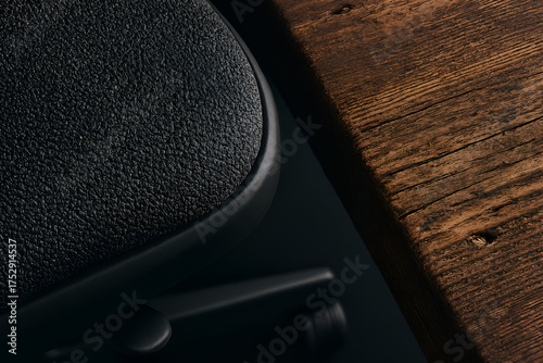 Modern ergonomic black leather office chair beside wooden desk