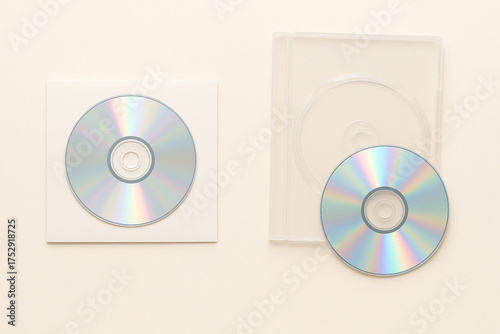 two compact disc isolated on cream color background