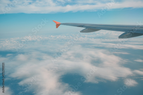 Wings touching the clouds on a sunny day during a tranquil flight over the open sky
