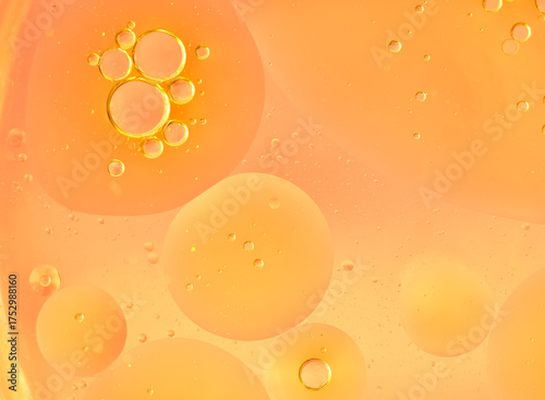 Orange abstract bubbles in liquid, macro. Different-sized clear bubbles float on a saturated orange background. Clean, warm composition, bright and modern, suitable for banners and backgrounds