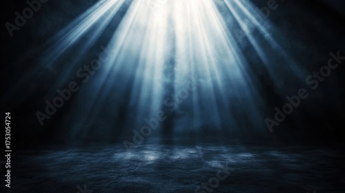 Spotlight bright beam illuminating empty dark stage floor with smoky atmosphere. Glowing light rays from top for theatrical background presentation.
