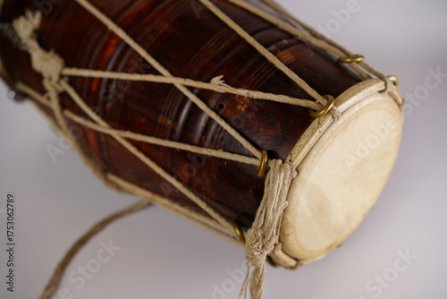 Handcrafted wooden drum displayed close-up, showcasing intricate details and traditional craftsmanship in natural light