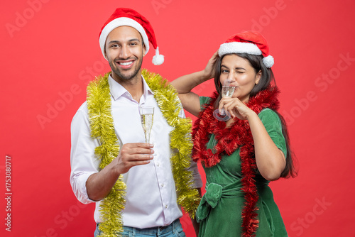 Photography Couple in Santa hats clinking champagne glasses celebrating Christmas Eve
