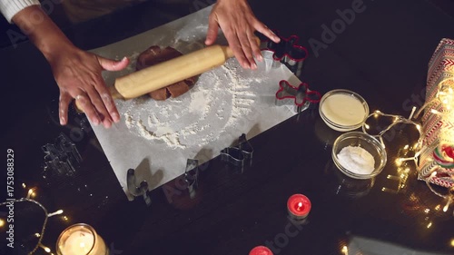 Baking Christmas Cookies: Hands Rolling Gingerbread Dough on a Festive Table with Holiday Lights