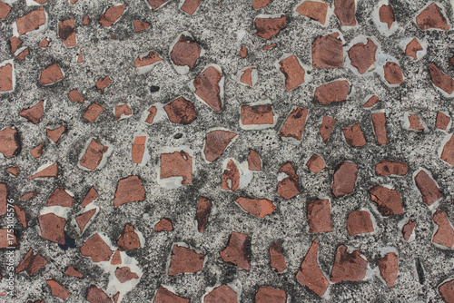 Close up of brown cobblestone background. Fragments of brown stones on gray asphalt texture.