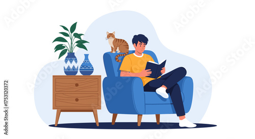 A young man enjoys reading a book while his cat sits on the armchair beside him.