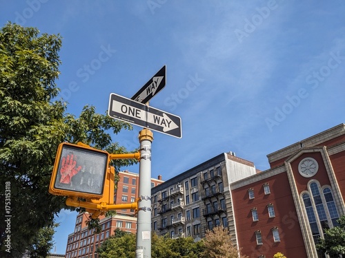 ニューヨークの街角にある「ONE WAY」標識と赤い手の歩行者信号
