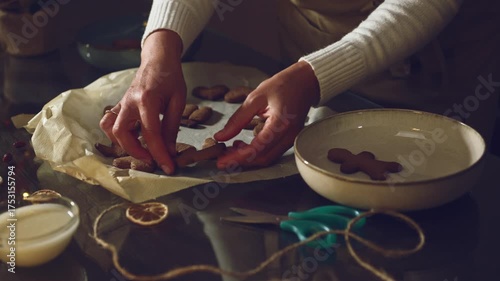 Hands Arranging Freshly Baked Gingerbread Cookies for Holiday Season