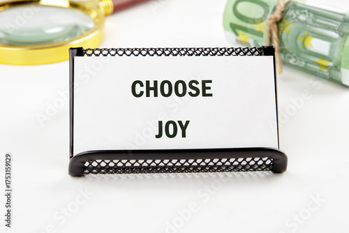 A motivational card reads Choose Joy, with a magnifying glass and Euros nearby. The composition suggests exploring financial freedom with positivity and reflection
