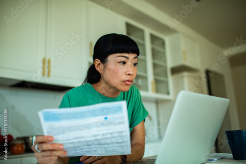 Young adult woman managing finances at home