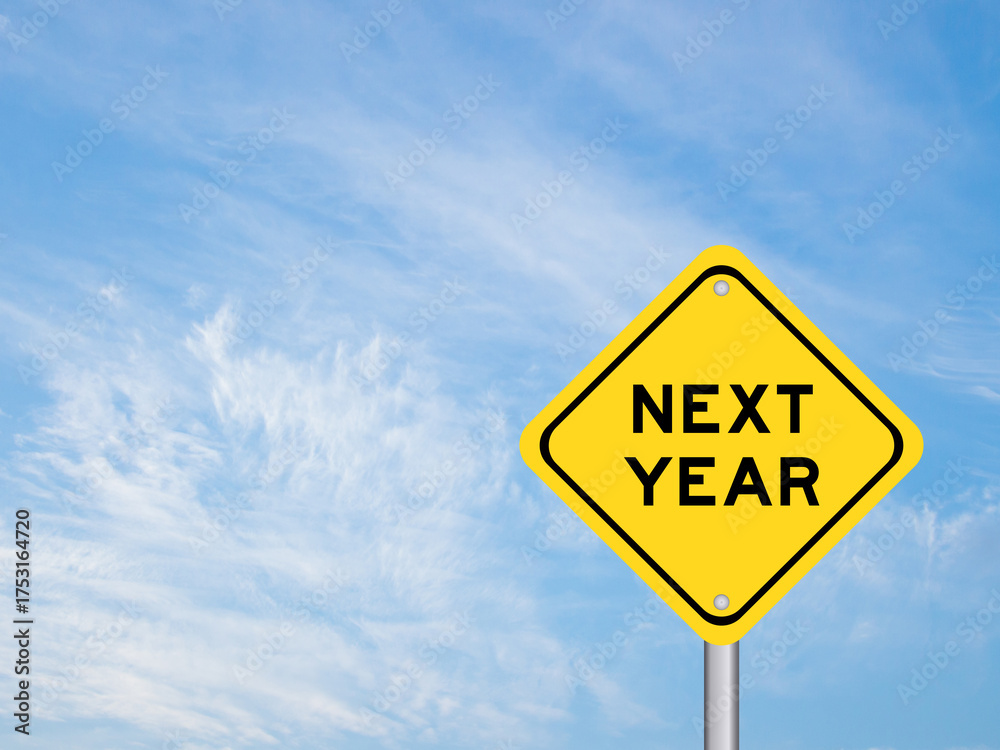 Naklejka premium Yellow transportation sign with word next year on blue color sky background