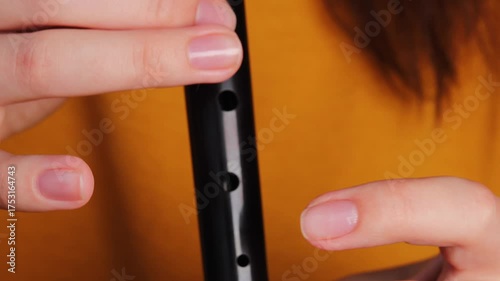Fingers hovering above recorder flute holes in detail