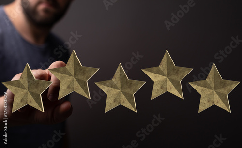 A person's hand holds five ...