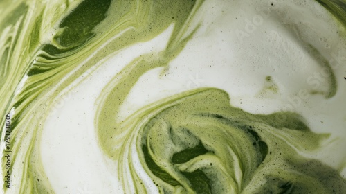 Close-up of creamy green matcha tea swirling with white milk, creating a dynamic and textured abstract marbled pattern suitable for food, beverage, and culinary backgrounds.