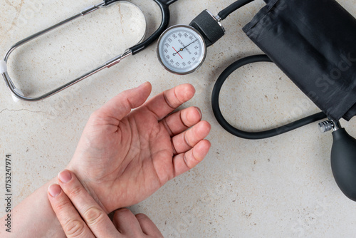 Doctor measuring blood pressure with tonometer and stethoscope on patient's hand, healthcare and medical diagnosis concept showing blood pressure control, prevention and heart care at home or clinic