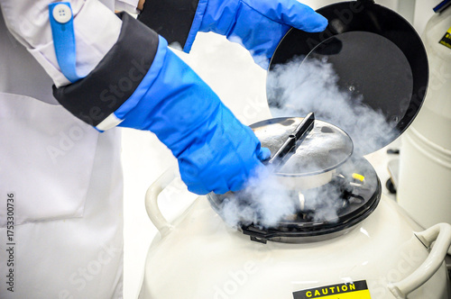 Fotografía Close-up scientist handling sperm freezing tank with liquid nitrogen in laborato