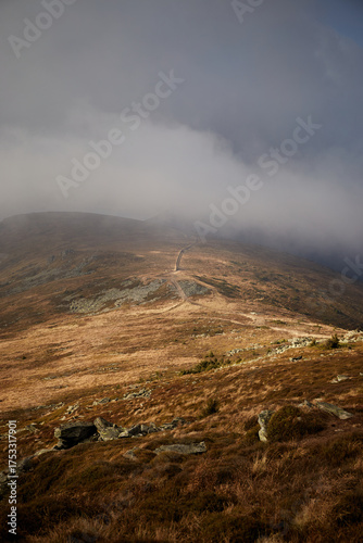 Scenic view from a mountain ridge showing clouds and distant hills during late afternoon. Autumn hiking in Carpathian Mountains, Ukraine