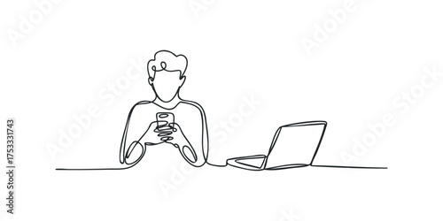 Person holding smartphone next to open laptop